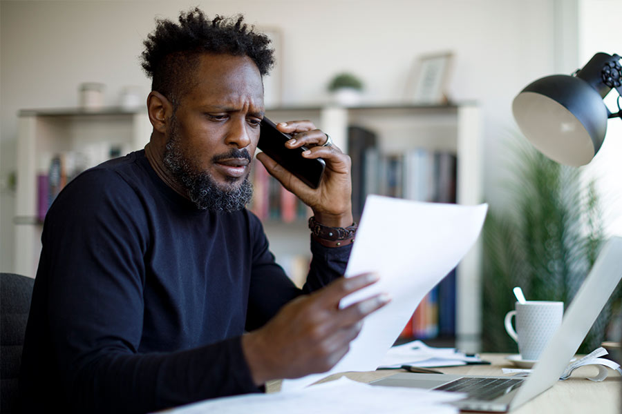 Concerned Man on His Phone While Looking at Some Documents