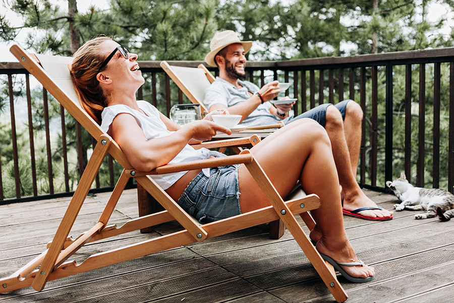 Man & Woman Drinking Tea With Cat on a New Deck