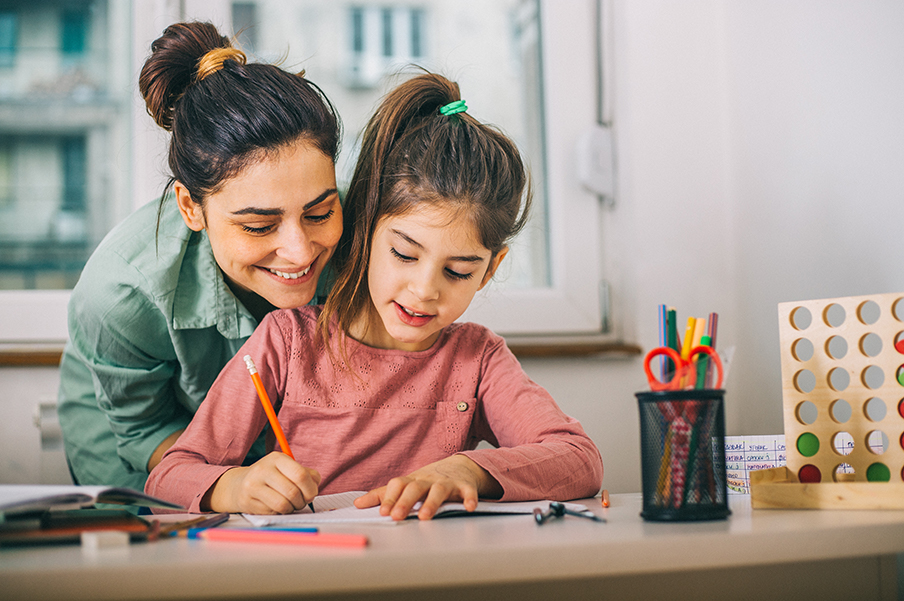 Mom helping her young daughter with homework.