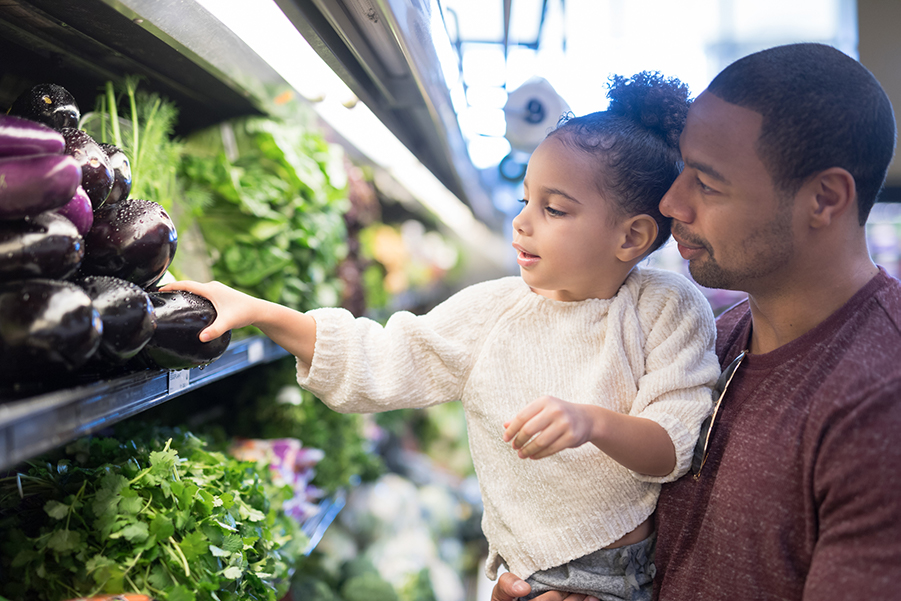 Father and Daughter Choosing Vegetables at a Grocery Store